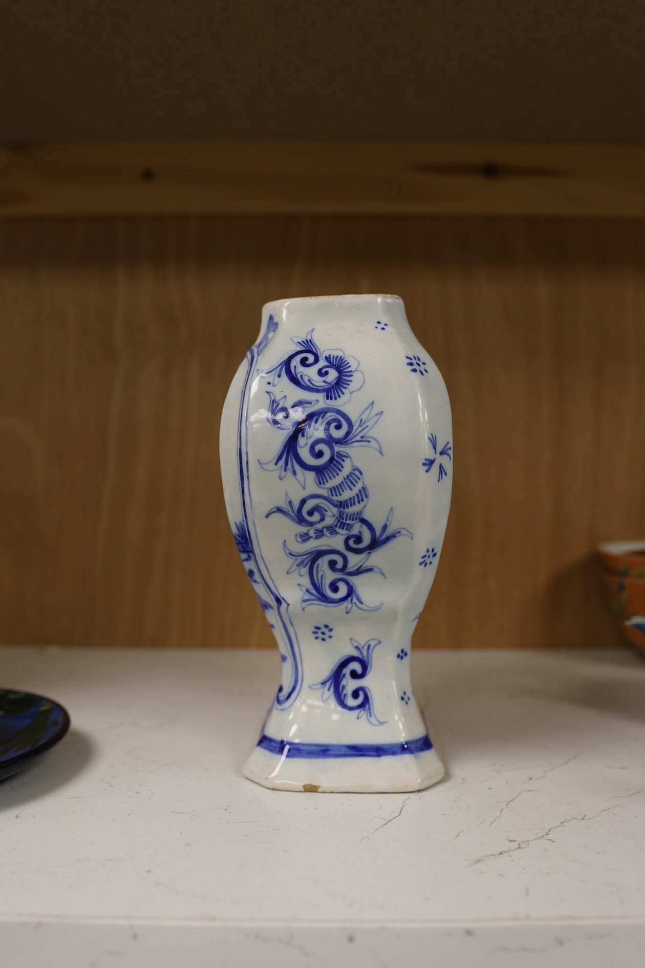 A 19th century Delft blue and white vase and a Watcombe Torquay pottery chamberstick, 19.5cm. Condition - both fair